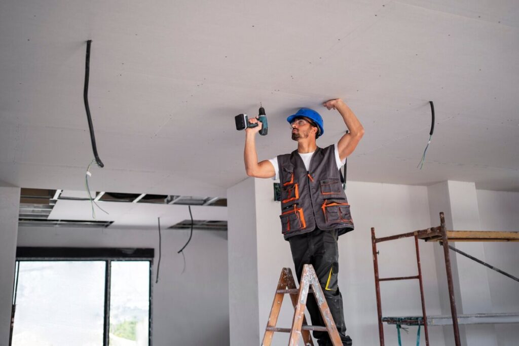 A construction worker fixing the ceiling