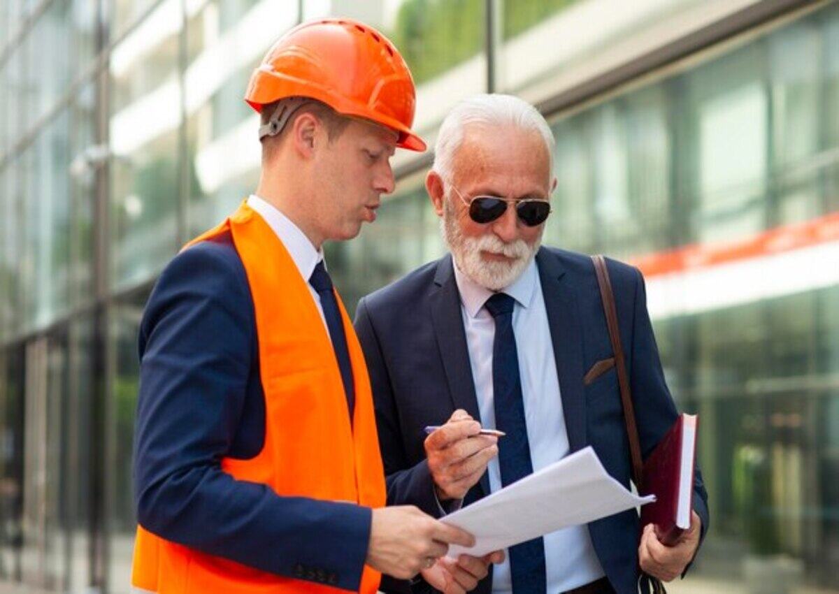 A contractor presents inspection documents to the business owner for the Commercial Building Remodeling project