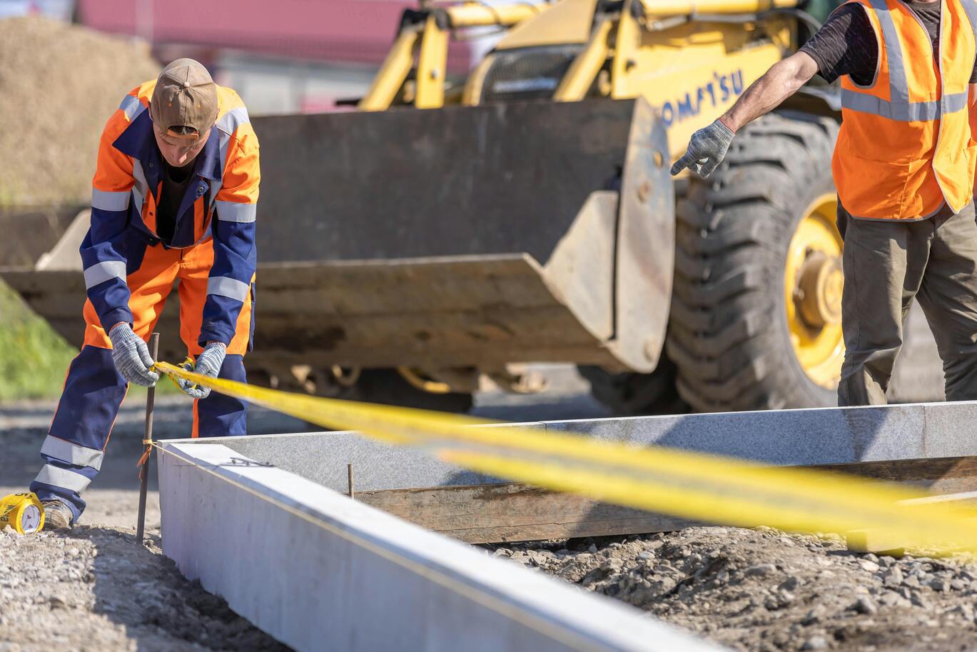 Skilled workers measuring the project site for a retail construction