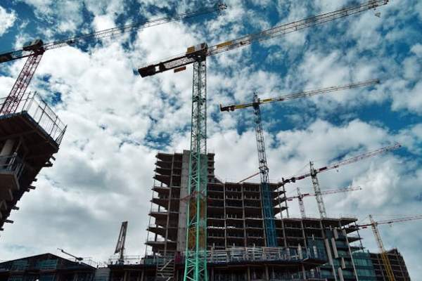 a green and yellow crane using in commercial building constructions