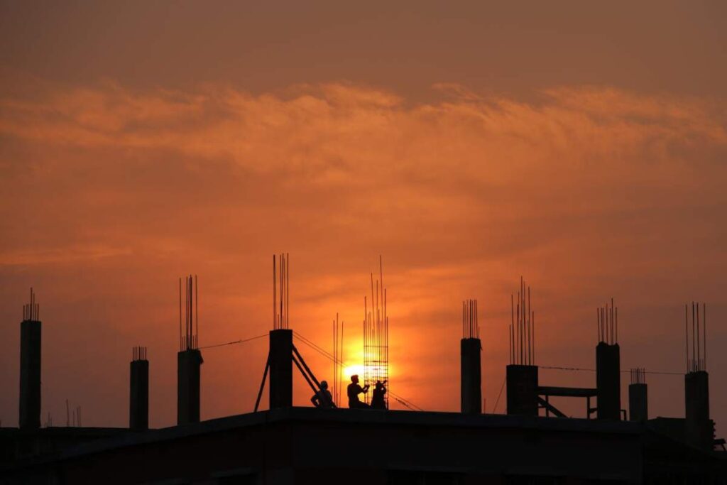 men in commercial building constructions site during sunset