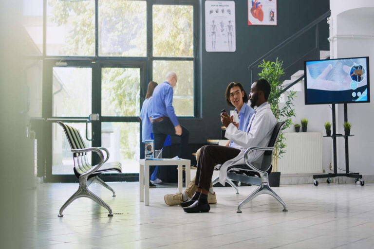 Doctors talking in modern medical office waiting area.