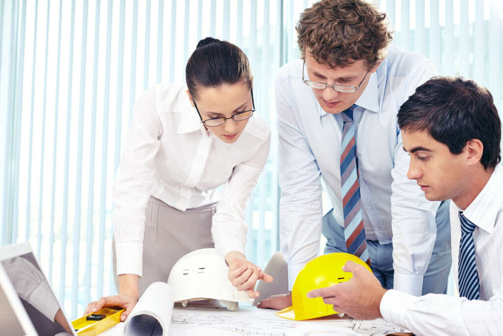 Architects and engineers reviewing medical office construction plans.