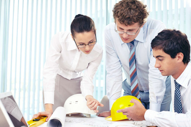 Architects and engineers reviewing medical office construction plans.