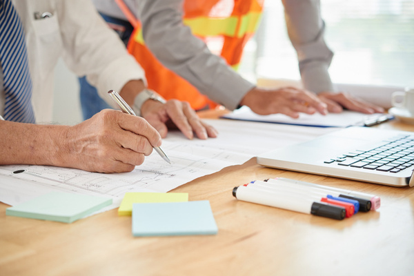 Engineers reviewing blueprints for medical office space construction.