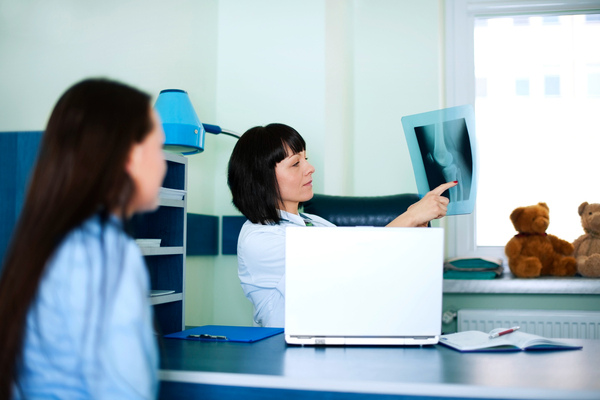 Doctor showing patient an X-ray in consultation room.