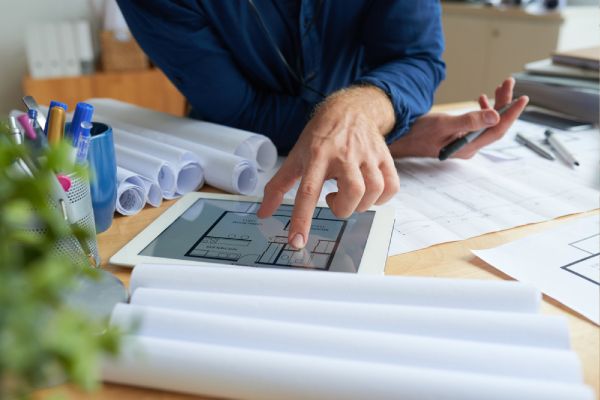 man sitting at desk planning with technical drawings
