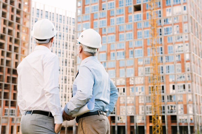 Engineers discuss differences between commercial and residential construction at building site.